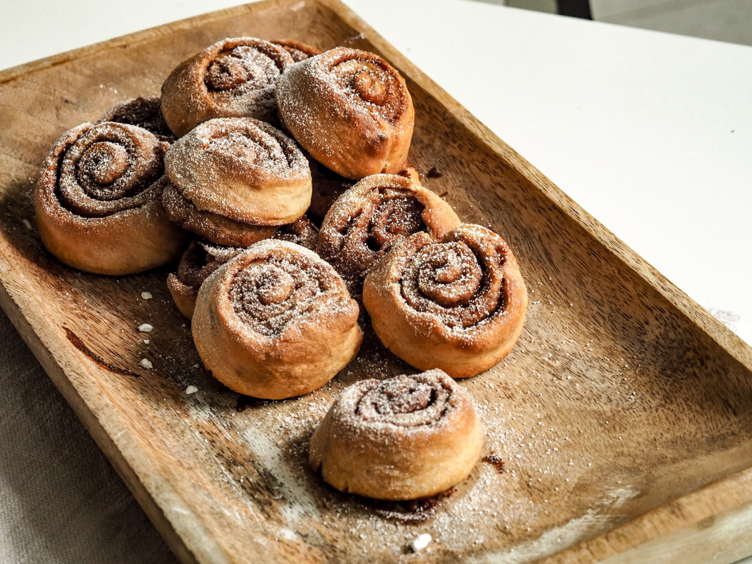 Cinnamon buns on a wooden serving platter. Cinnamon buns contain gluten which is the centre of some popular nutrition myths.
